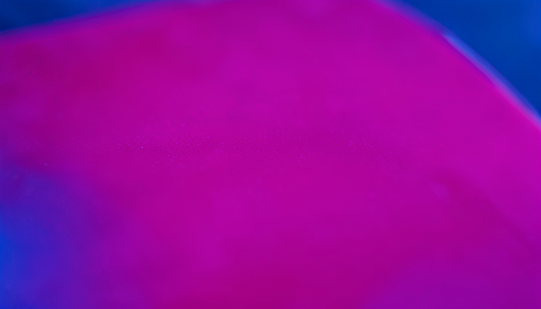 Extreme close-up of glossy magenta acrylic sheet with soft gradient lighting